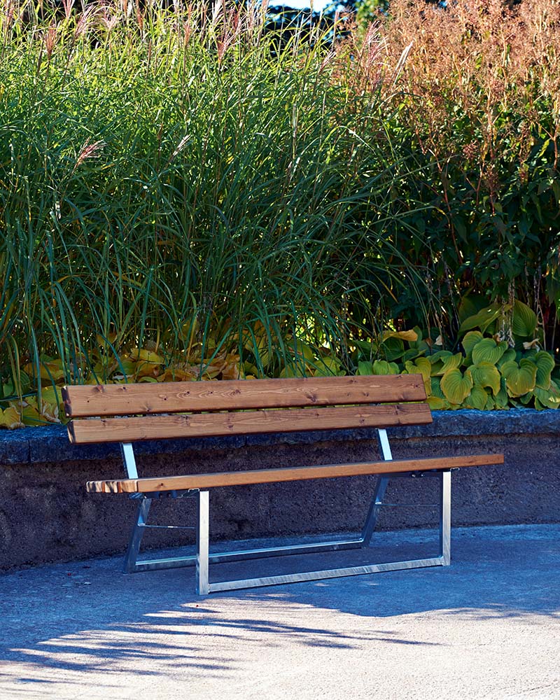 An Ekeby park bench in a park envirionment.
